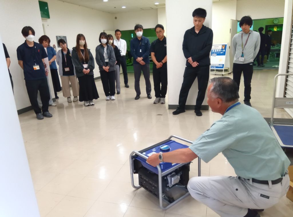 市の職員が発動発電機の操作要領を実習している様子