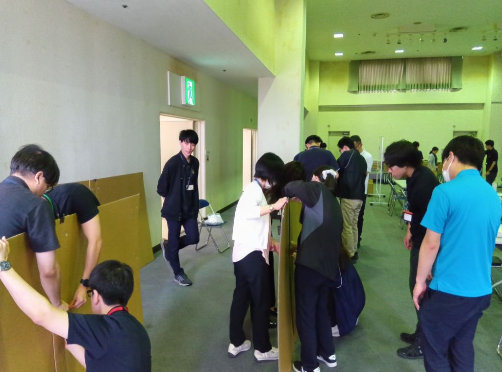 市の職員が避難所用の間仕切りダンボールを組み立てている様子